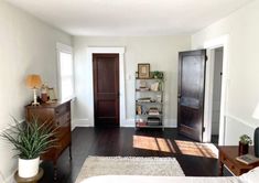 a bedroom with hardwood floors and white walls