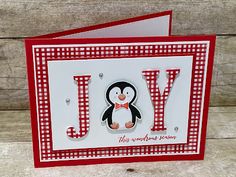 a card with a penguin on it and the word joy is spelled in red letters