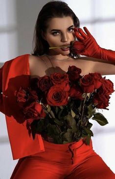 a woman in red is posing with roses