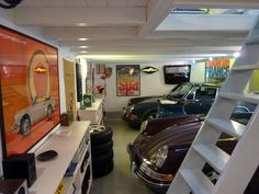 there are many cars in this garage and one is on the wall with ladders