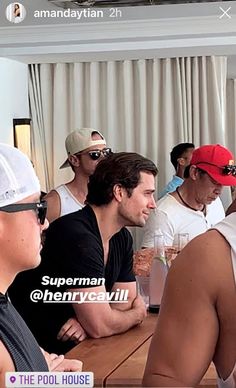 a group of men sitting at a table with drinks in front of them and the caption reads, superman @ henrycavilli