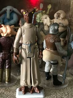 star wars action figures on display in a room with other toy figurines behind them