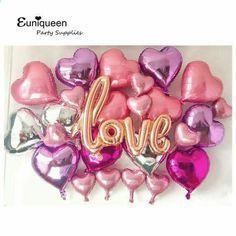 heart shaped balloons with the word love spelled out in gold and pink foil on white background