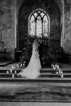 a bride and groom standing at the alter in front of candles for their wedding ceremony