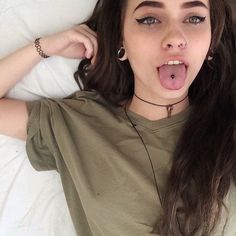 a woman laying in bed making a funny face with her tongue hanging out to the side