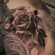 a black and white rose tattoo on the chest