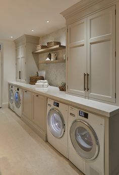 a washer and dryer in a very large room with cabinets on both sides