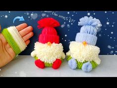 three small knitted toys sitting on top of a white table next to a hand