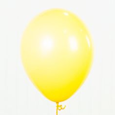 a large yellow balloon is being held up by a small metal pole with a wire attached to it