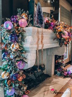 a fireplace decorated with ornaments and garlands in purple, pink, gold and green colors