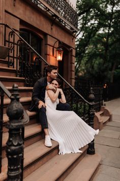 a man and woman sitting on the steps of a building