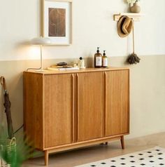 a wooden cabinet sitting in the corner of a room next to a potted plant