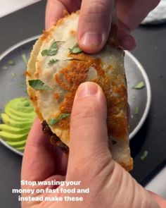 a hand holding a piece of food over a plate