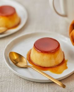 two plates with desserts on them and gold spoons next to each other,