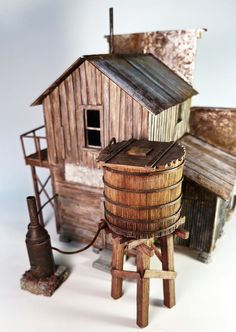 an old fashioned wooden house with a water well next to it