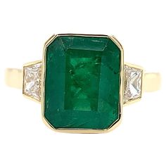 Green emerald and diamond trilogy cocktail ring 18 yellow gold Green emerald natural gemstone emerald shaped total weight approximately 3.50ct Diamond step cut total weight 0.80ct F colour VS1 clarity The ring can be resized Ring size N Hallmarked Band width 2.5mm Box and valuation included. Luxury Gold Emerald Ring With Fusion Style, Emerald Art Deco, Emerald Art, Rings Art Deco, Art Deco Emerald Ring, Resize Ring, Step Cut, Art Deco Ring, Green Emerald