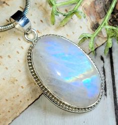 "Natural High Grade Multi Flash Moonstone Oval Cabochon .925 Sterling Silver Pendant.  Measures 1 3/4\" x 7/8\" weighs 9.8 grams HD42. Hard to find this kind of quality  Moonstone! Gorgeous top grade Moonstone. MUCH prettier in person! This is a handpicked natural stone, the exact one shown in picture.  The sterling silver is .925 and stamped.  Each piece is handmade by artisans in my shop.  The quality of the stones and the silver craftmanship is impressive.   Please look at other items in my store.  I sell ready made jewelry with handcrafted silver work, pendants with a sterling silver bails and beautiful unique stones for jewelry wire wrapping and weaving. You will pay exact amount on shipping plus $1 for supplies and labor. All items are shipped within a couple of days after payment an Oval Cabochon Moonstone Jewelry, Oval Moonstone Natural Stones, Oval Natural Moonstone Gemstones, Oval Silver Moonstone Gemstones, White Oval Cabochon Jewelry With Large Stone, Oval Moonstone Jewelry With Natural Stones, White Moonstone Jewelry Oval Cabochon, Untreated Oval Silver Gemstones, Oval Cabochon Moonstone Jewelry With Natural Stones