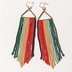 multicolored seed beaded earrings hanging from gold hooks on white background with clippings