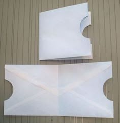 two pieces of white paper sitting next to each other on top of a building wall