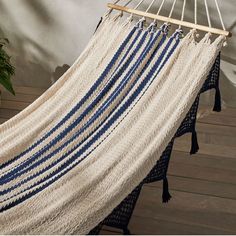 a white and blue striped hammock hanging from a wooden pole