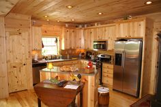 a kitchen with wood paneling and stainless steel appliances