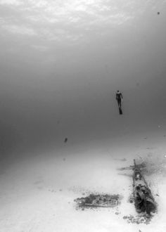 a man is diving in the ocean with an object on the bottom of the water