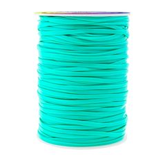 a spool of turquoise colored wax cord on a white background with clippings