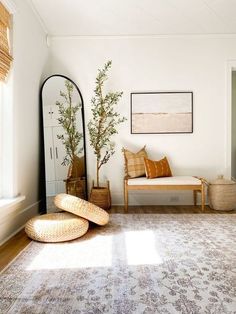 a living room with white walls and wooden furniture, including a large mirror on the wall