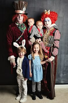 a group of children standing next to each other wearing costumes and clowns on their heads