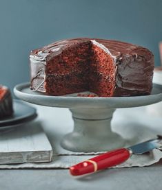 a chocolate cake on a plate with one slice cut out