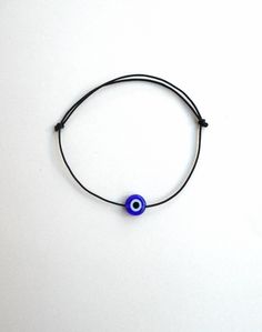 Evil eye bracelet, String bracelet, Black string, Nylon string, Protection amulet, family gift ideas, Simplicity, Dainty bracelet, Minimal Perfect for gift for families! Choose this bracelet to avoid annoying cords hanging. Made from quality nylon string and a glass eye bead of 8mm. Can be adjusted onto your wrist by pulling the knots on each side. Black Evil Eye Bracelet With Sliding Knot As Gift, How To Make Anklets, Rat Jewellery, Evil Eye Anklet, Dainty Anklet, Bracelet String, Gifts For Surfers, Beach Anklets, Mens Gold Jewelry