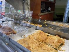 some food that is sitting on top of a metal counter in a store front window