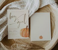 two cards with pumpkins on them are sitting on a wooden bowl next to a white blanket