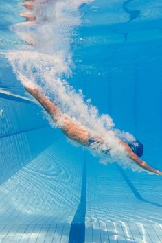 an underwater view of a man swimming in the pool