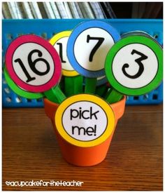 three cupcakes with numbers on them sitting in front of a pile of books