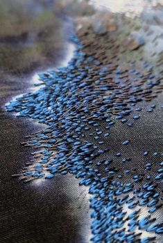 a close up view of blue and black fabric with small holes in it's center