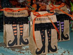 two brown paper bags with black and orange striped stockings on them, tied to each other