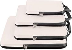 three pieces of white and black luggage sitting side by side on top of each other