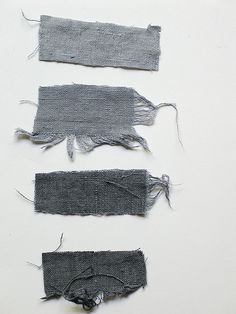 three pieces of gray fabric are shown on a white surface, and one piece has been torn off