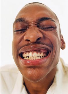 a close up of a person with a toothbrush in his mouth and one eye closed