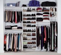 an organized closet with white shelves filled with clothes and shoes