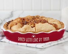 a large pie sitting on top of a counter next to a glass bottle and napkin