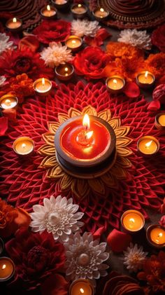 a candle is lit in the center of a circular arrangement of flowers and petals, surrounded by candles