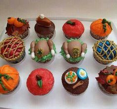 there are many cupcakes on the tray with different designs and shapes in them