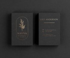 two black business cards with gold foil on the front and back, sitting next to each other