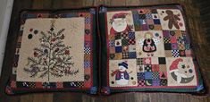 two quilted christmas pillows sitting on top of a wooden floor next to each other