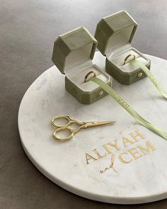 there is a pair of scissors and two boxes on top of a marble plaque that says alvyah chem