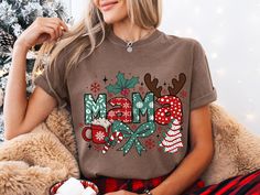 Get into the holiday spirit with this cozy and festive "Mama" Christmas design! This t-shirt is perfect for moms to wear during the holiday season. It features a cute and playful design with Christmas elements like reindeer antlers, snowflakes, and a hot cocoa mug. The soft and comfortable Comfort Colors fabric ensures you'll stay warm and stylish all season. Looking for a unique Christmas T-shirt? Look no further! This eye-catching design is sure to spread holiday cheer and spark conversations. Whether you're rocking it solo or as part of a family Christmas photo, this shirt is a guaranteed crowd-pleaser. Available in a variety of sizes to ensure a comfortable fit for everyone. This is the perfect Christmas gift for yourself, your loved ones, or anyone who loves to celebrate the holiday s Christmas Elements, Reindeer Antlers, Christmas Family Photos, Family Christmas Shirts, Christmas Mom, Crowd Pleaser, Christmas Photo, The Perfect Christmas, Christmas T Shirt