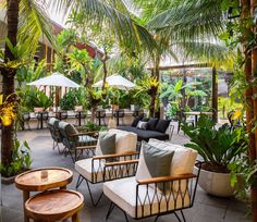 an outdoor seating area with tables, chairs and umbrellas in the middle of it