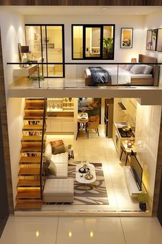 an aerial view of a living room and bedroom area in a house with stairs leading up to the second floor